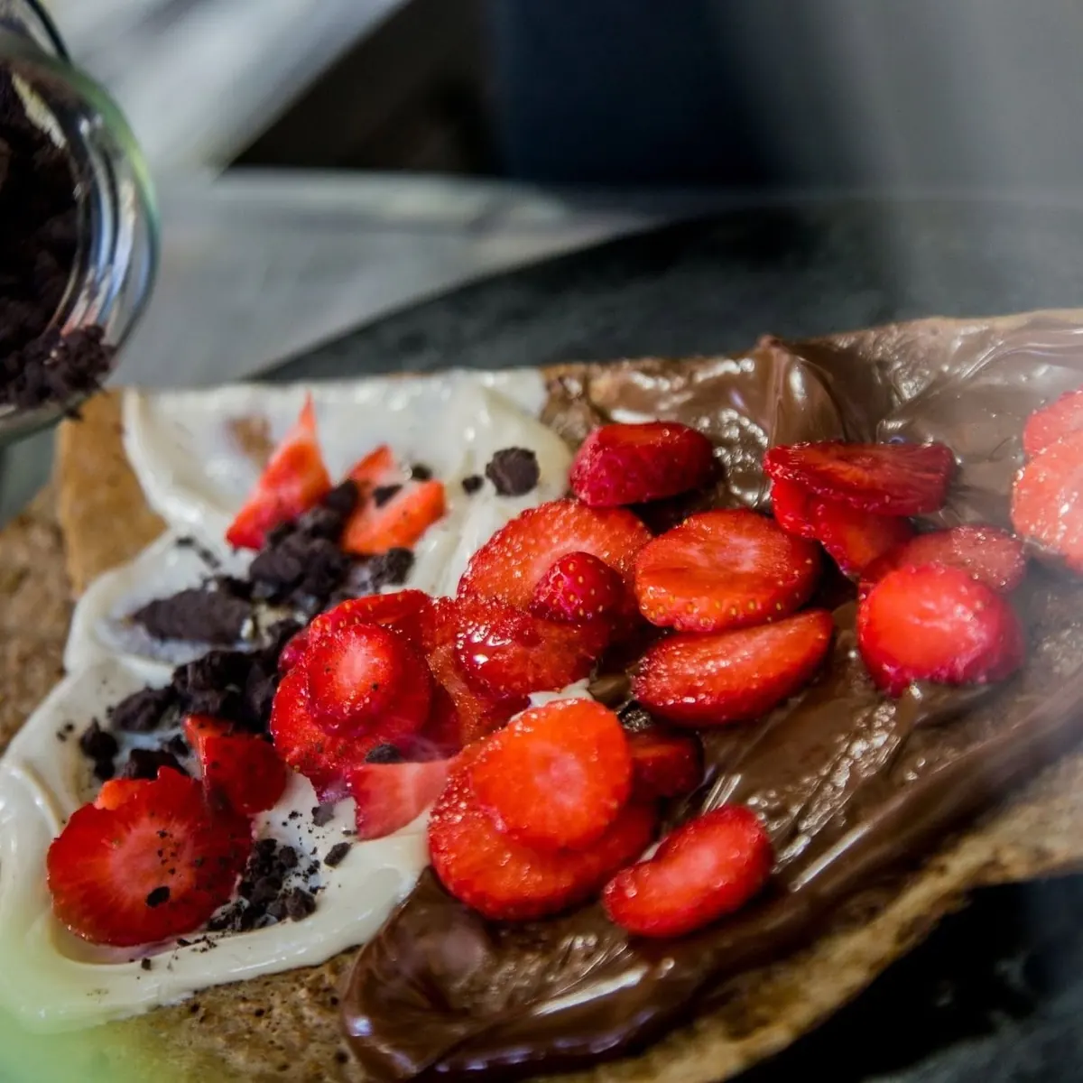 A sweet crepe piled with strawberries, Nutella, white chocolate and Oreo crumbs
