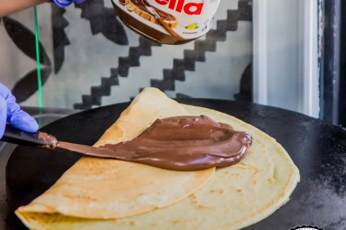 Spreading Nutella on a fresh crepe