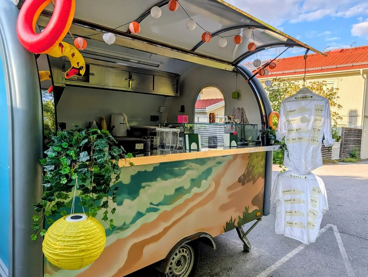 The trailer set up with lanterns and the menu boards